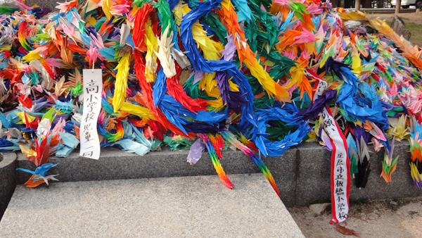 a close view of the chains of paper cranes of many colours
